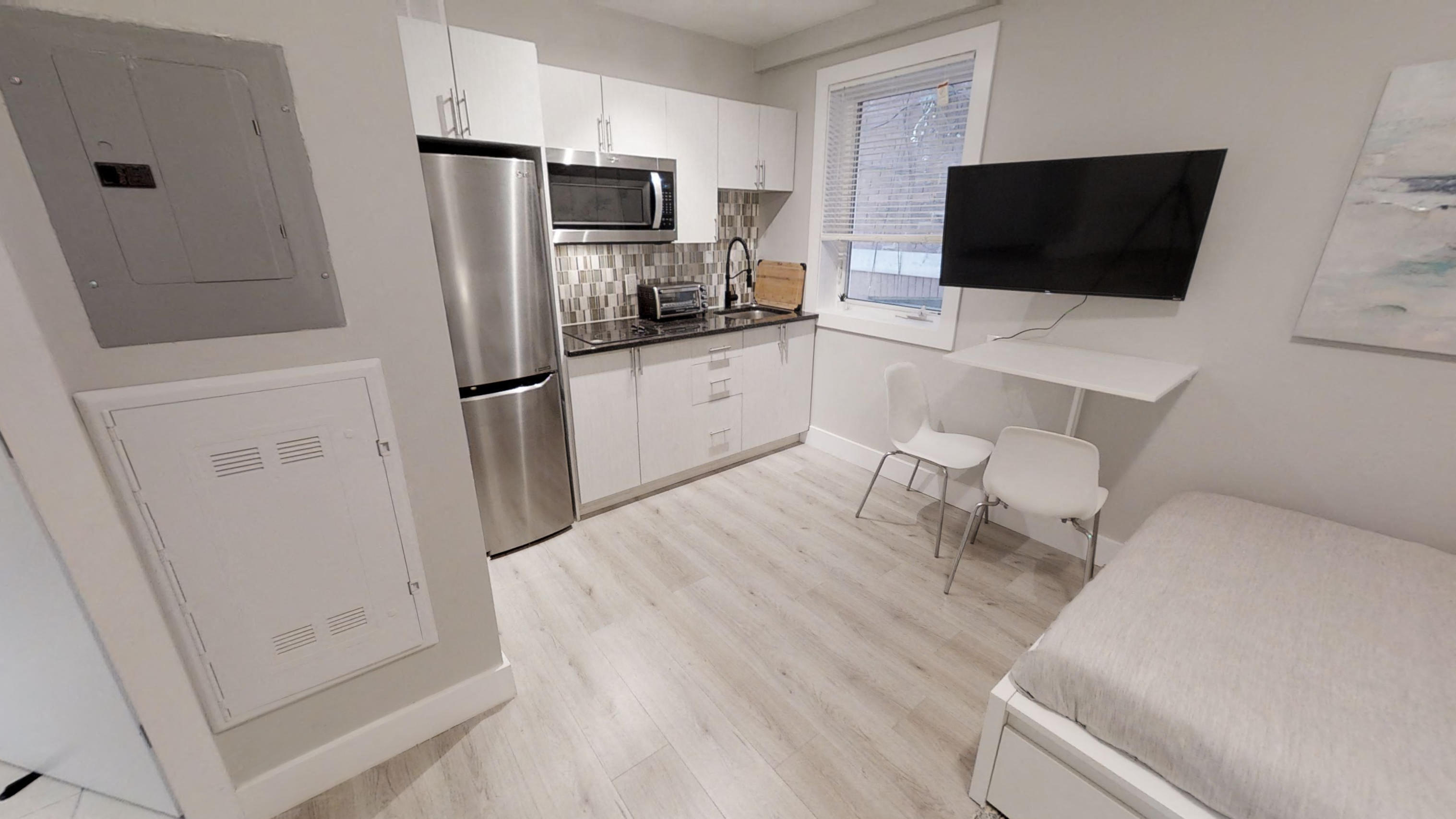 a small kitchen with a desk and a refrigerator